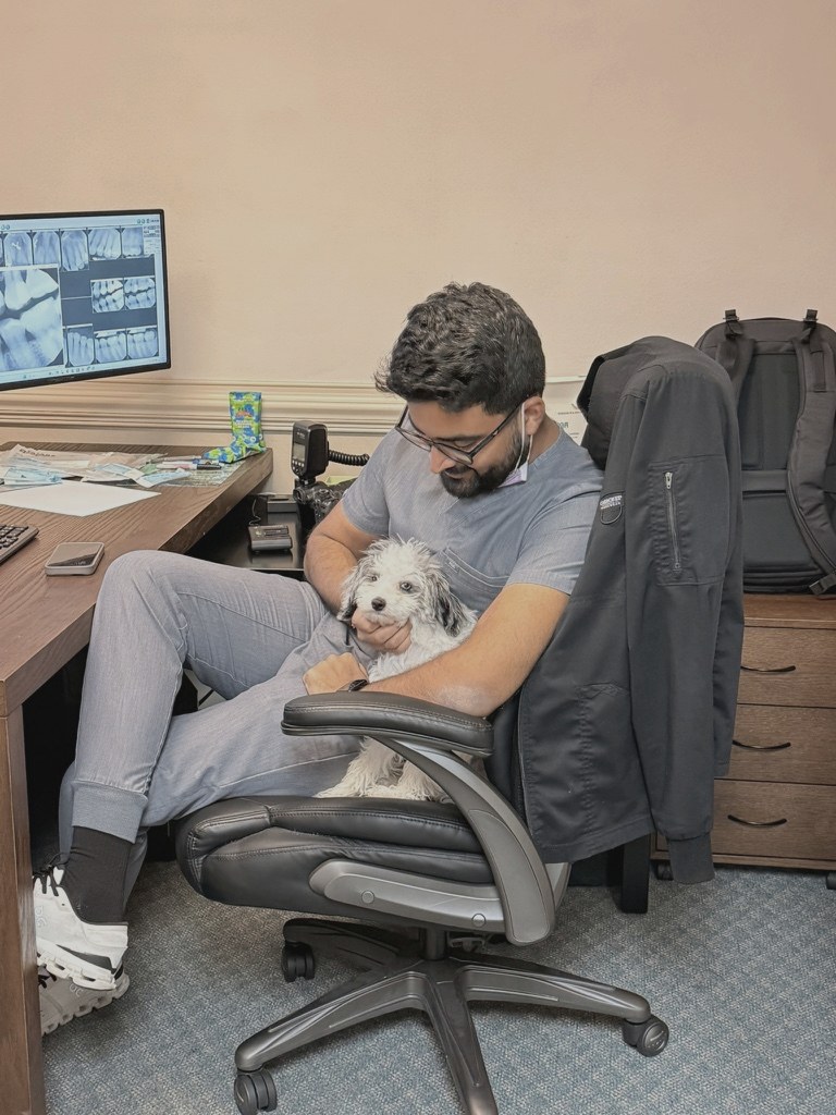 Dr. Nishant with the office puppy on his lap.